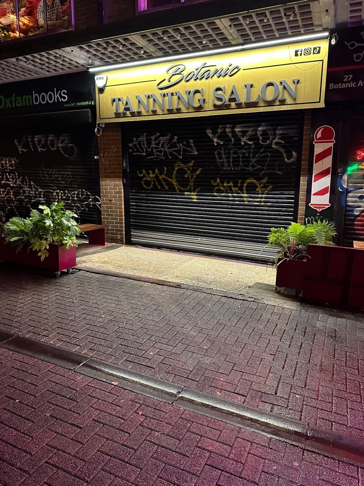 Shopfront and paving outside a tanning salon at night