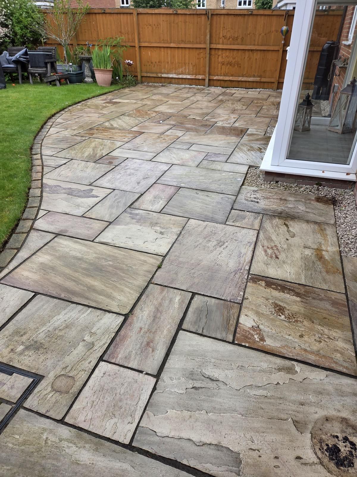 Sandstone flagstone patio beside a lawn