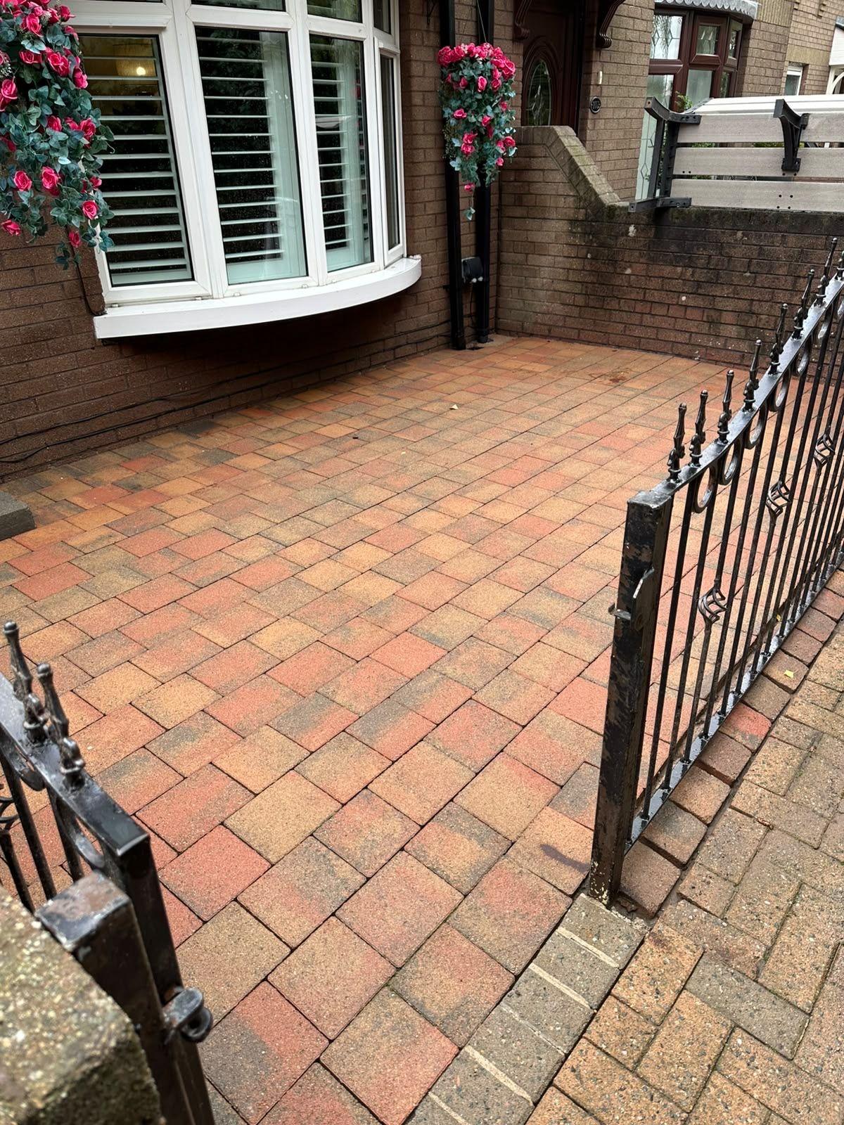 Block paving front path with a black metal gate